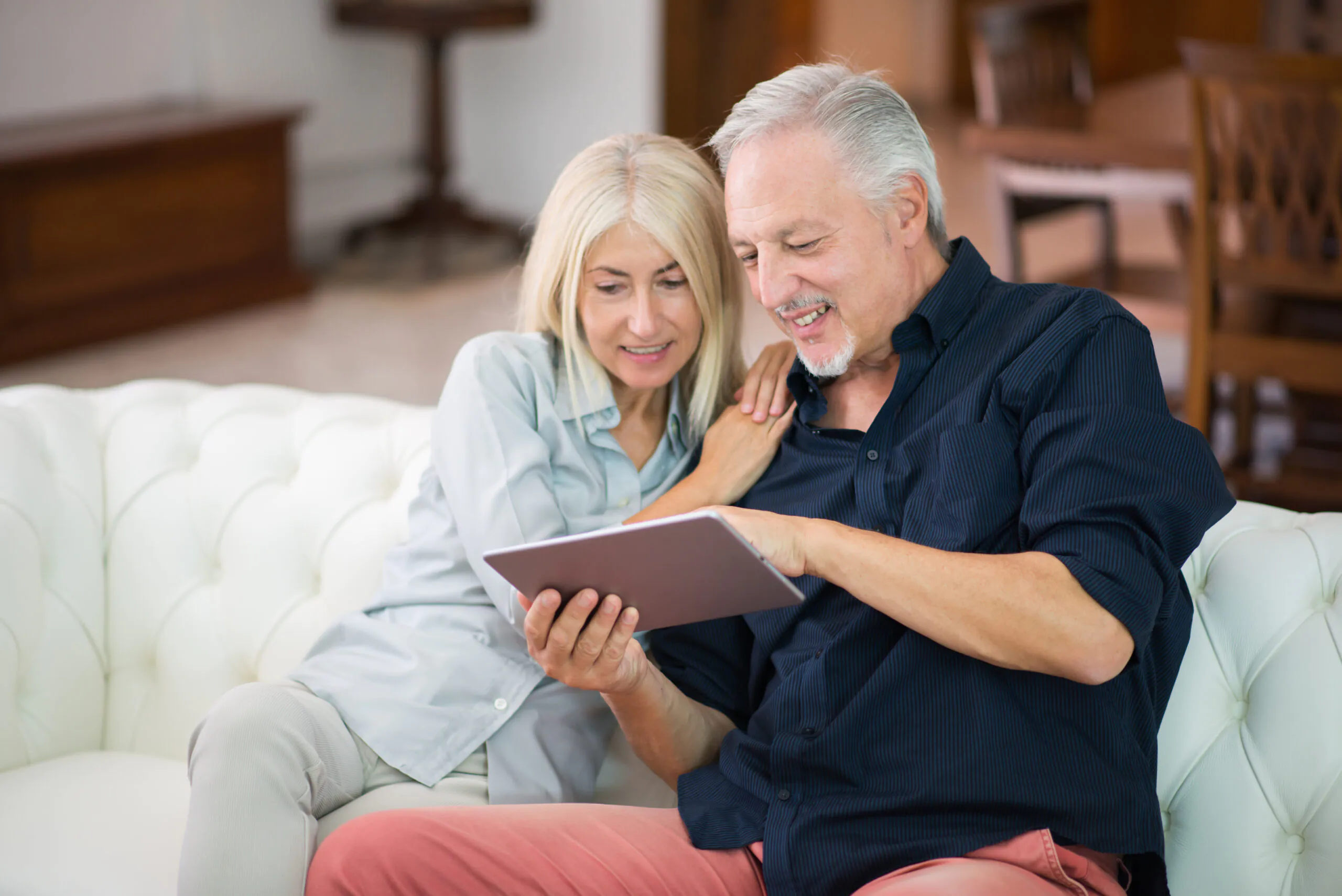 Two people sitting on a sofa looking at a tablet together | Lafford Group