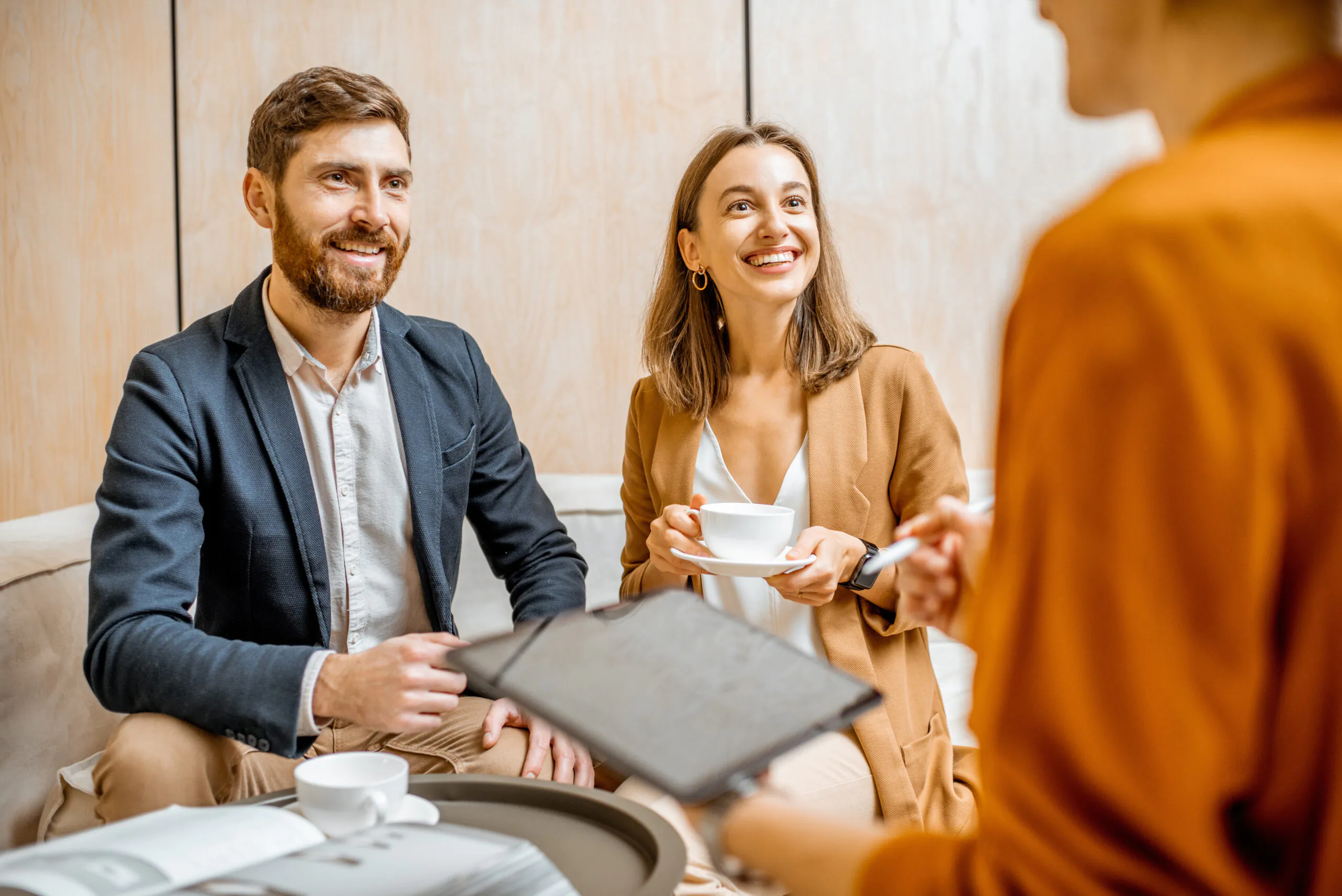 A couple meeting with a representative to review paperwork over coffee | Lafford Group