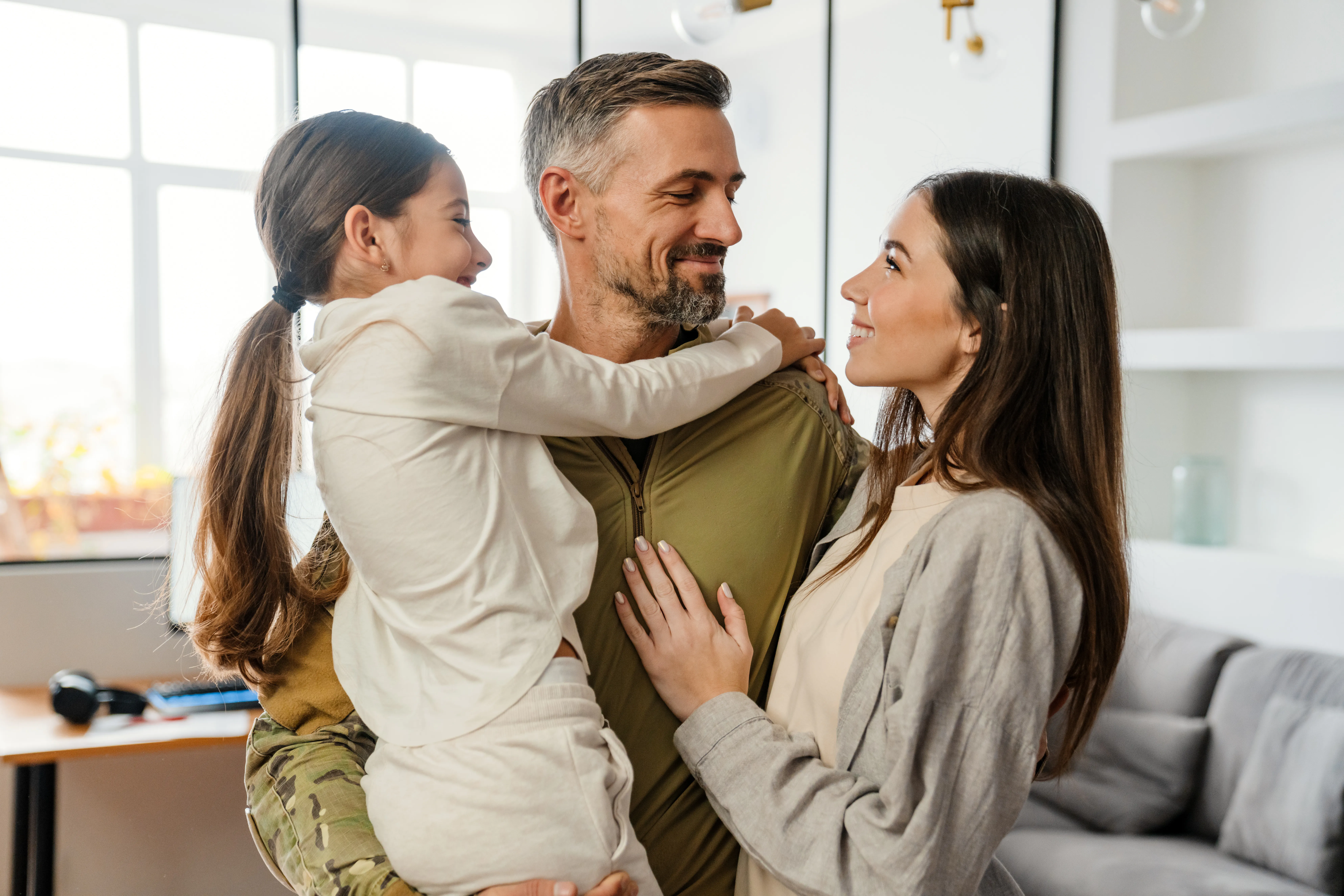 Two adults and a child in a home setting, one adult holding the child | Lafford Group