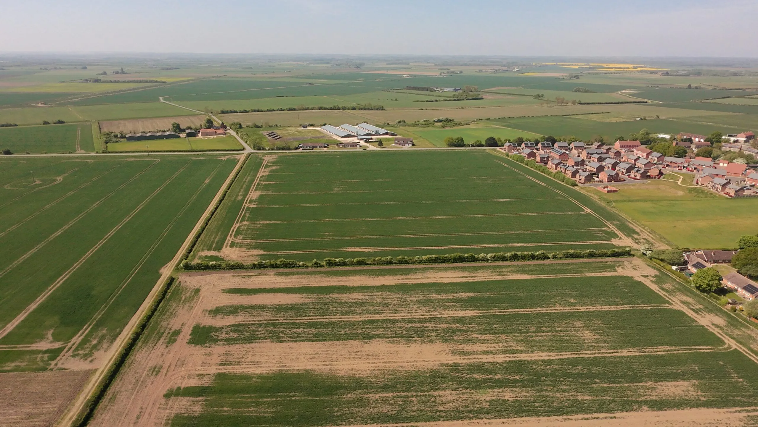 Aerial view of agricultural land adjoining a residential development.