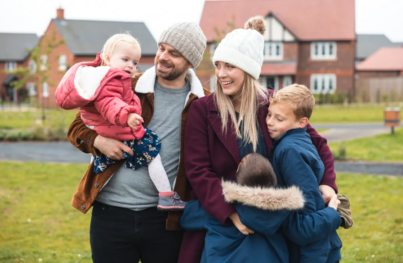 Family gathered outside homes within a modern residential community/