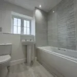 Family bathroom with shower over bath in The Bardney, Plot 45 at Beacon Hollow.