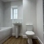 Family bathroom with shower over bath in The Ruskington, Plot 48 at Beacon Hollow