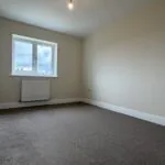 The Waltham at Petrella Place – Bedroom 2 with neutral décor, fitted carpet, double-glazed window and radiator beneath.