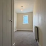The Caister at Petrella Place – Bedroom 3 with fitted carpet, neutral décor, a single window at the far end and a wall-mounted radiator.
