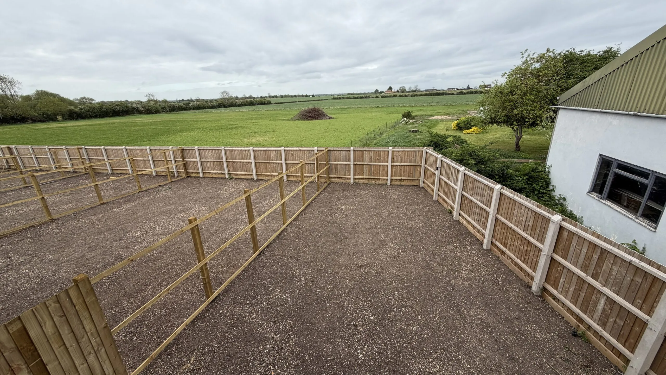 Petrella Place rear gardens view showing Plot 22 on the right and Plot 21 on the left, with fenced boundaries and open countryside beyond.