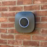 Rolec electric vehicle car charger mounted on a red brick wall at Petrella Place, with a circular charging socket and illuminated ring.