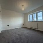 Principal bedroom at 34 Warwick Drive featuring soft grey carpeting, multiple windows providing excellent natural light and generous floor space for a double bed and bedroom furniture.