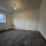 Bedroom Two at 34 Warwick Drive featuring soft grey carpeting, a rear-facing window providing natural light and a spacious layout suitable for a double bed and additional furniture.
