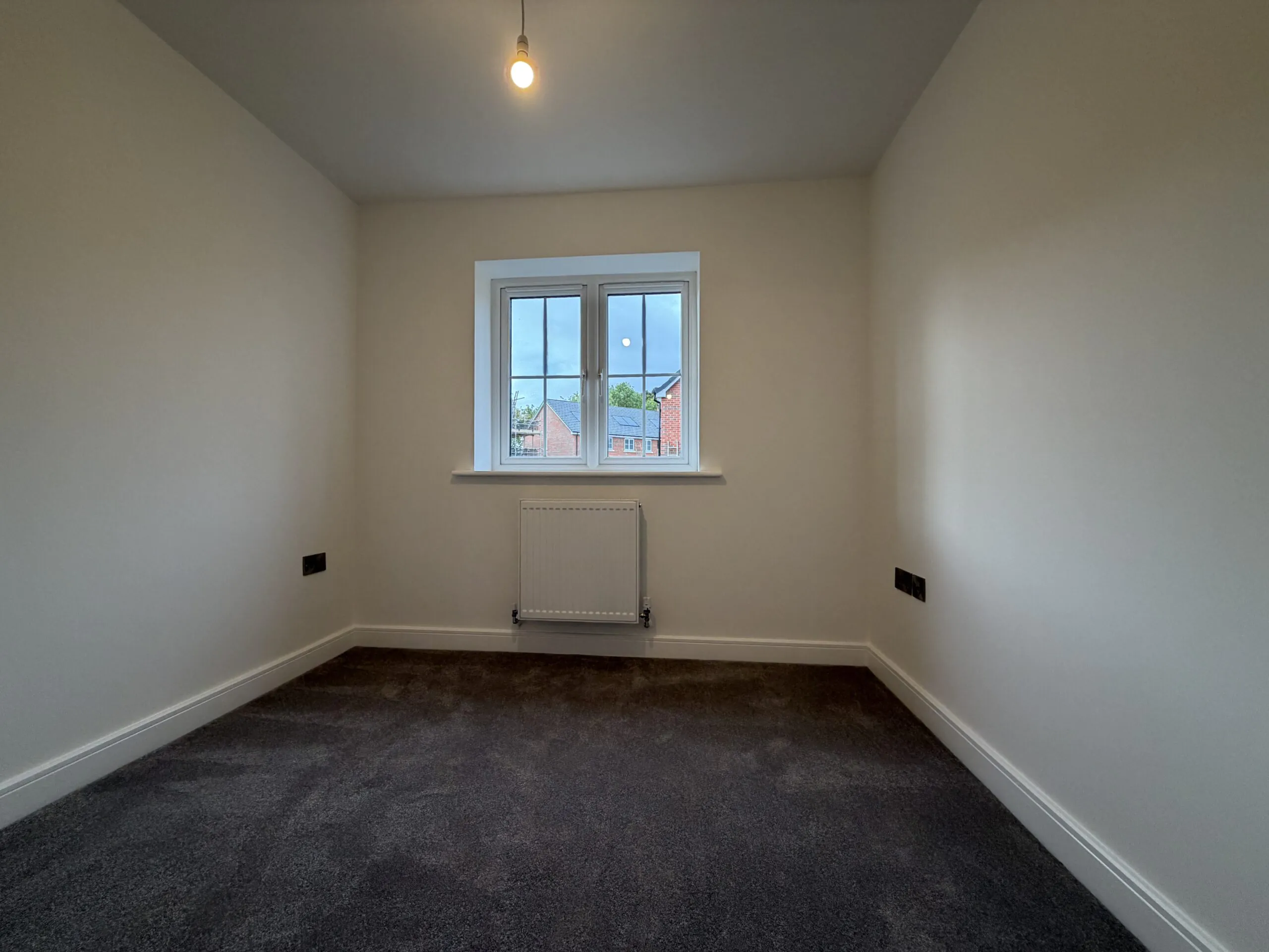 Bedroom Three at 34 Warwick Drive featuring soft grey carpeting, neutral décor, a front-facing window and a versatile layout suitable for a child's bedroom, nursery or home office.